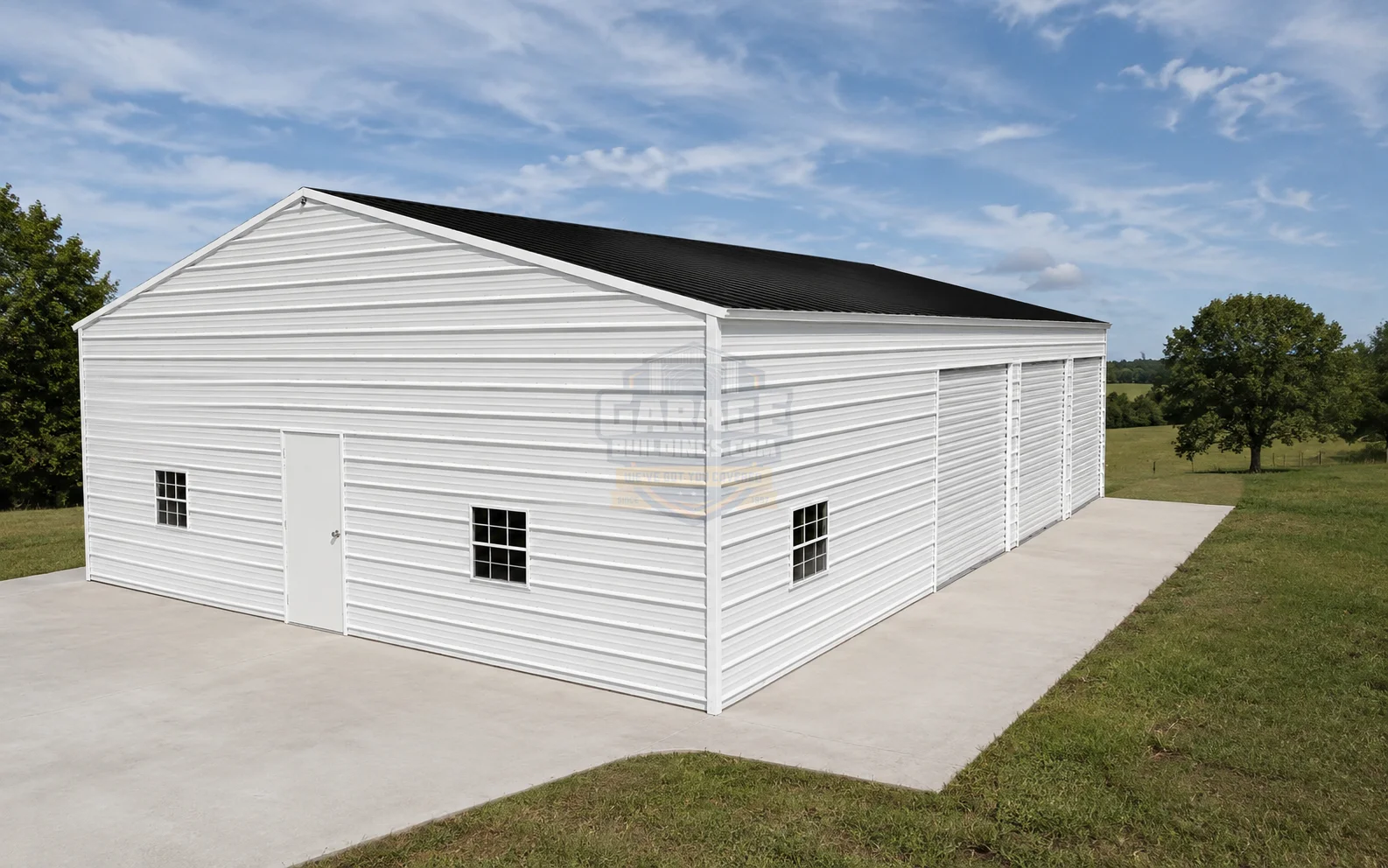 Large white metal barn with a black roof on grassy land