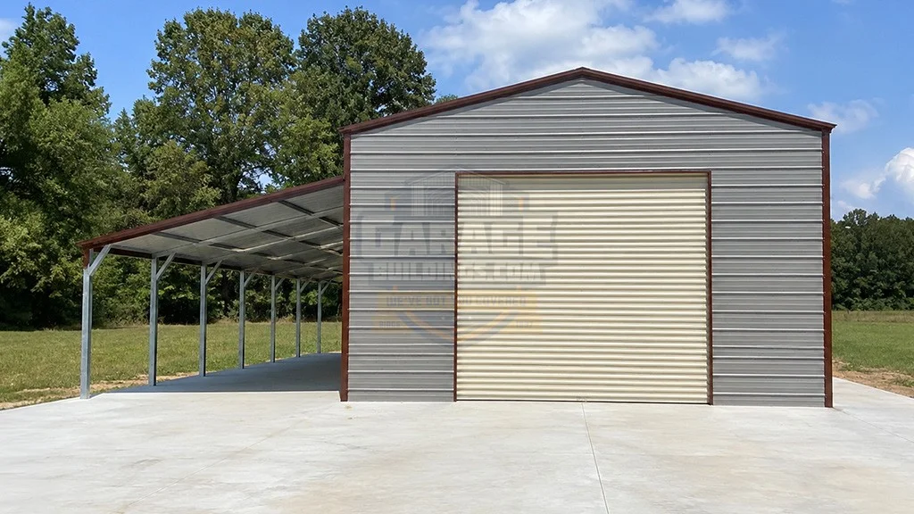 Steel storage building with a roll-up door and covered area, surrounded by green trees