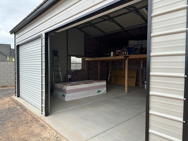 Open garage with shelving and stacked materials inside