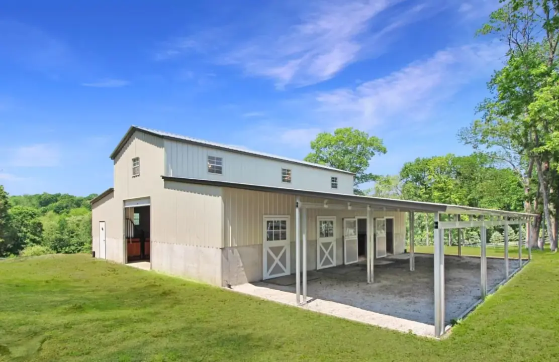Modern barn building with covered patio and grassy surroundings