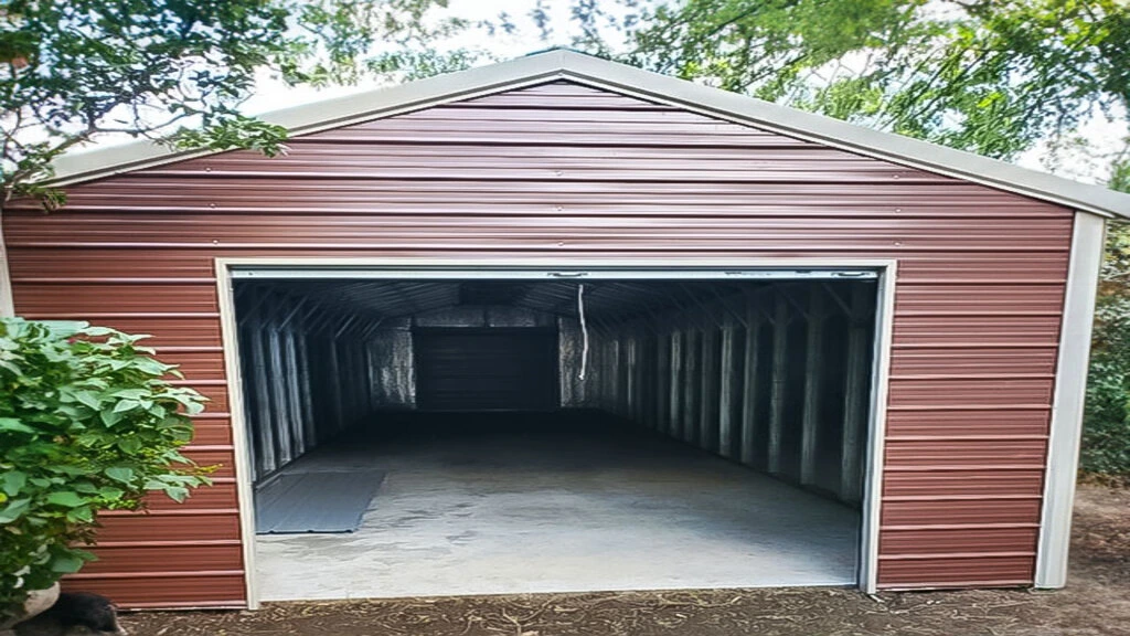 Metal storage shed with a large open doorway, surrounded by greenery