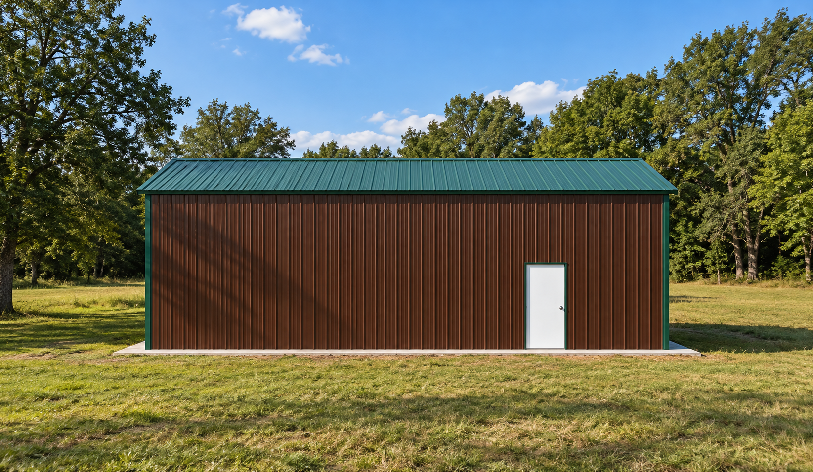 Brown metal building with a green roof and side door, set in a grassy field