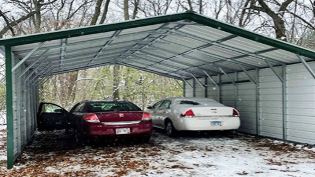 Two cars parked under a metal carport in snowy conditions
