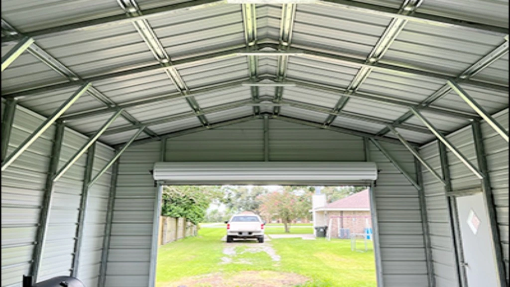 Interior view of a metal shed with garage door and greenery outside