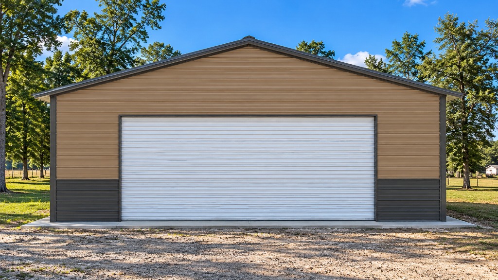 Large garage building with a tan and gray exterior surrounded by trees